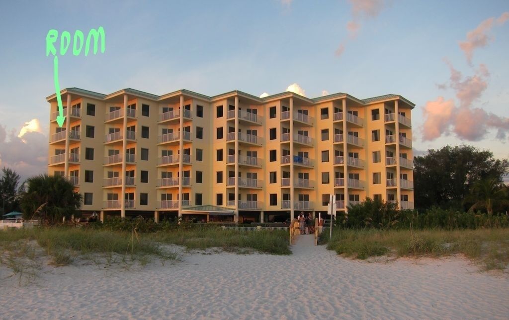 Un hotel de varios pisos con balcones, cerca de una playa.