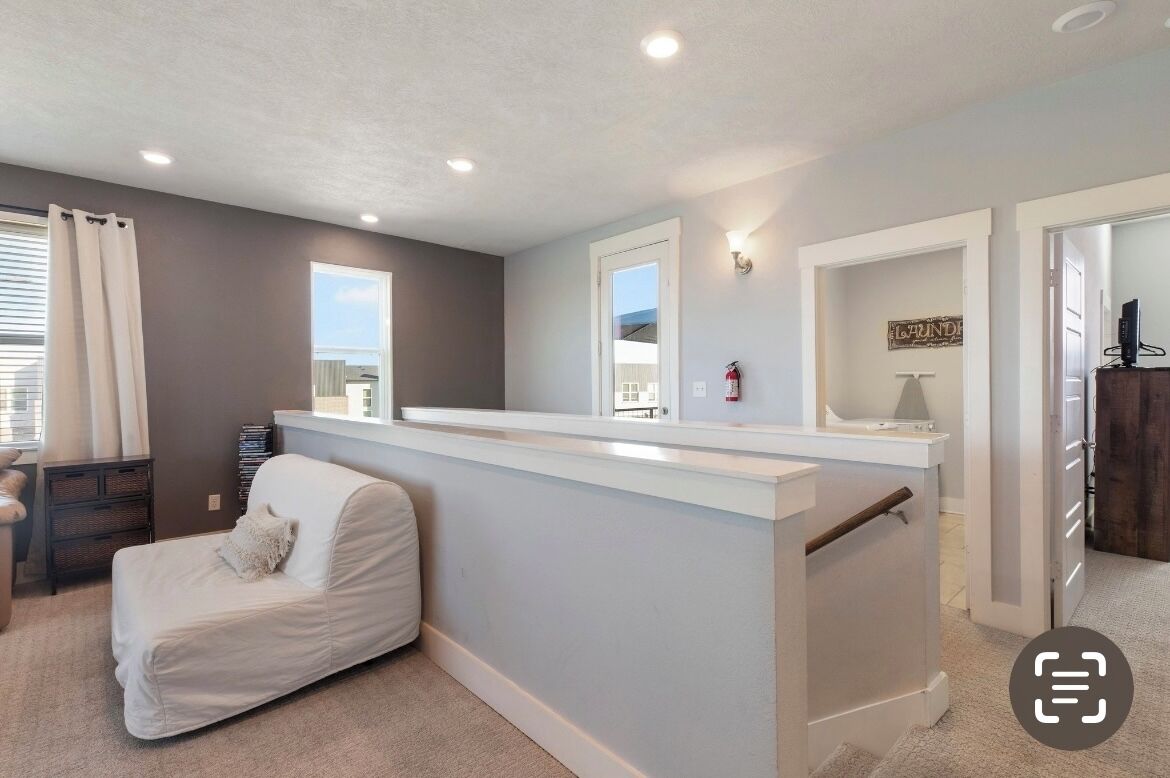A modern living room with a white sofa, a small table, and a window.