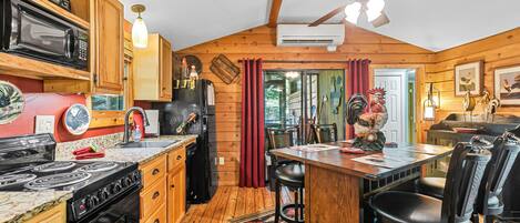 Una cocina con armarios de madera, estufa, refrigerador y ventilador de techo.