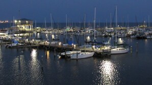 Un port esportiu a la posta de sol amb diverses embarcacions amarrades.