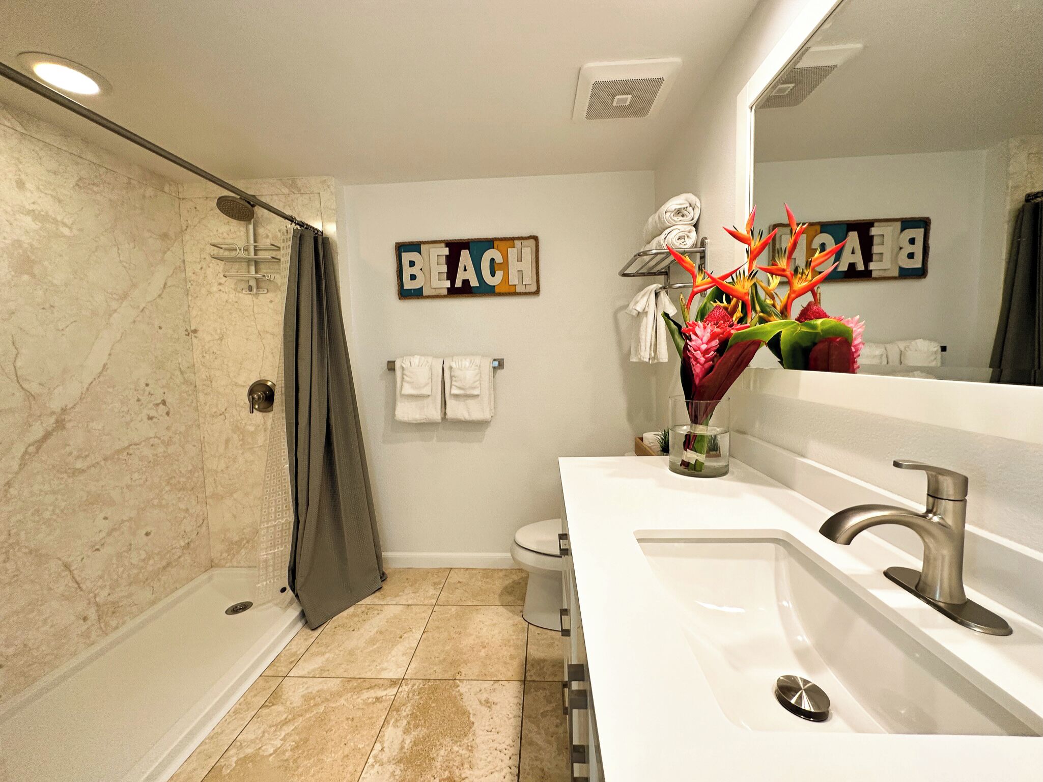 A modern bathroom with a shower, toilet, and sink.