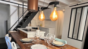 A modern dining area with a wooden table set for six, a kitchen island, and a staircase. - TOP LOCATION, TOP CENTER , POMPIDOU/MARAIS/LOUVRE (Paris)