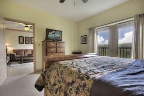 A bedroom with a large bed, a dresser, a television on the dresser, and a view of the outdoors through a sliding door. - John's Mtn Blessing  w/ 2 Pools, Hot tub, Arcade Games 7 BR & 6 BA.  Sleeps 20+ (Pigeon Forge)