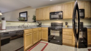 A modern kitchen with wooden cabinets, stainless steel appliances, and granite countertops. - John's Mtn Blessing  w/ 2 Pools, Hot tub, Arcade Games 7 BR & 6 BA.  Sleeps 20+ (Pigeon Forge)