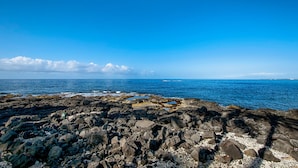 Una costa rocosa con aguas azules cristalinas y un horizonte lejano.