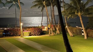 A nighttime view of a golf course with palm trees and a view of the ocean. - Oceanfront 2BR_2BA Kihei Maui–Stunning Lanai Sunsets, Beach Front, Turtles! (Kihei)