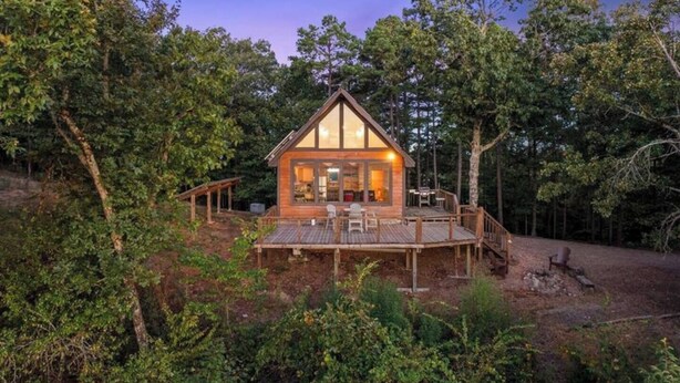 A wooden cabin with a deck, surrounded by trees. - Cliffside Escape | Epic Lake Views & Off-Grid Stay (Broken Bow)