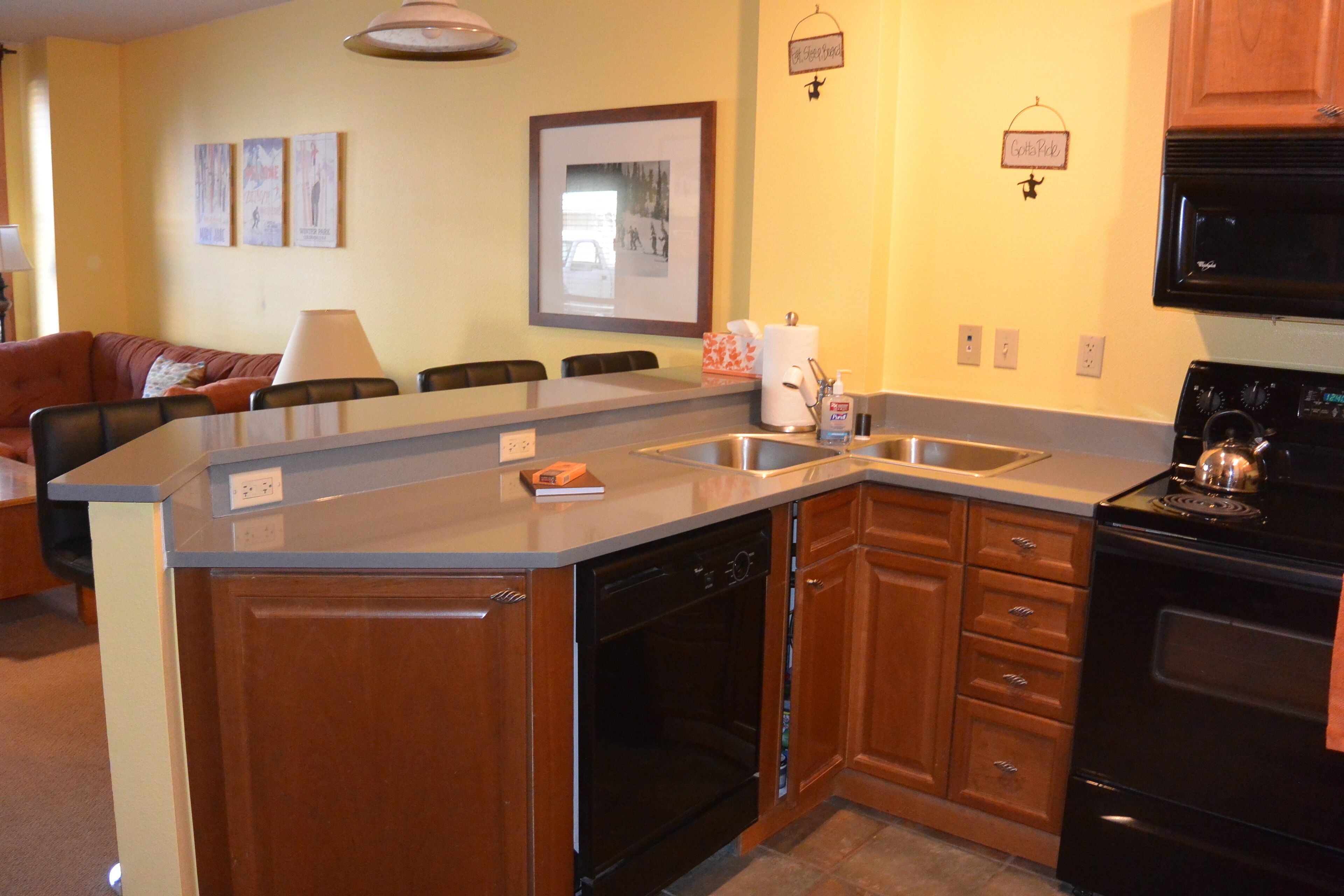 A kitchen with wooden cabinets, a built-in dishwasher, a stove, and a microwave.