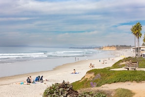 A beach with people sunbathing and walking along the shore. - Live the Beach Life in a Quaint Shell Cottage (Del Mar)