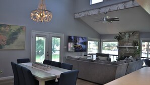 A modern kitchen with a dining area, a large window, and a ceiling fan.