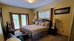 Un dormitorio con cama, sofá, escritorio y ventana.