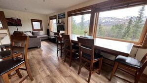 Un salón amplio con una gran mesa de comedor, sillas de madera, un sofá y una chimenea.