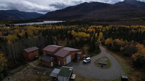 Una propiedad rural con una casa principal, una cabaña más pequeña y un garaje independiente.