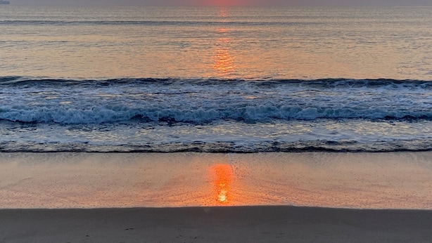 A sunset over the ocean with waves on the shore. - Sea La Vie: Ocean Side North End 3-Bedroom  - 2 min Walk to Beach (Virginia Beach)