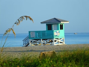 Situated on the beach, this lifeguard station offers a raised platform with a sloped roof and seating area.