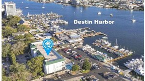 An aerial view of Destin Harbor with a marina, boats, and buildings. - DESTIN HARBORWALK BEST LOCATION in DESTIN with Boatdock (destin)