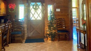 Un interior de madera con tragaluces, un árbol de Navidad y una zona de comedor.