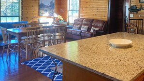 Un interior de madera con comedor, zona de estar y encimera de cocina.