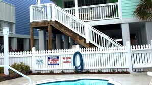 A two-story house with a balcony and a swimming pool.