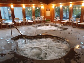 Relax in the serene spa area with two hot tubs surrounded by comfortable seating.