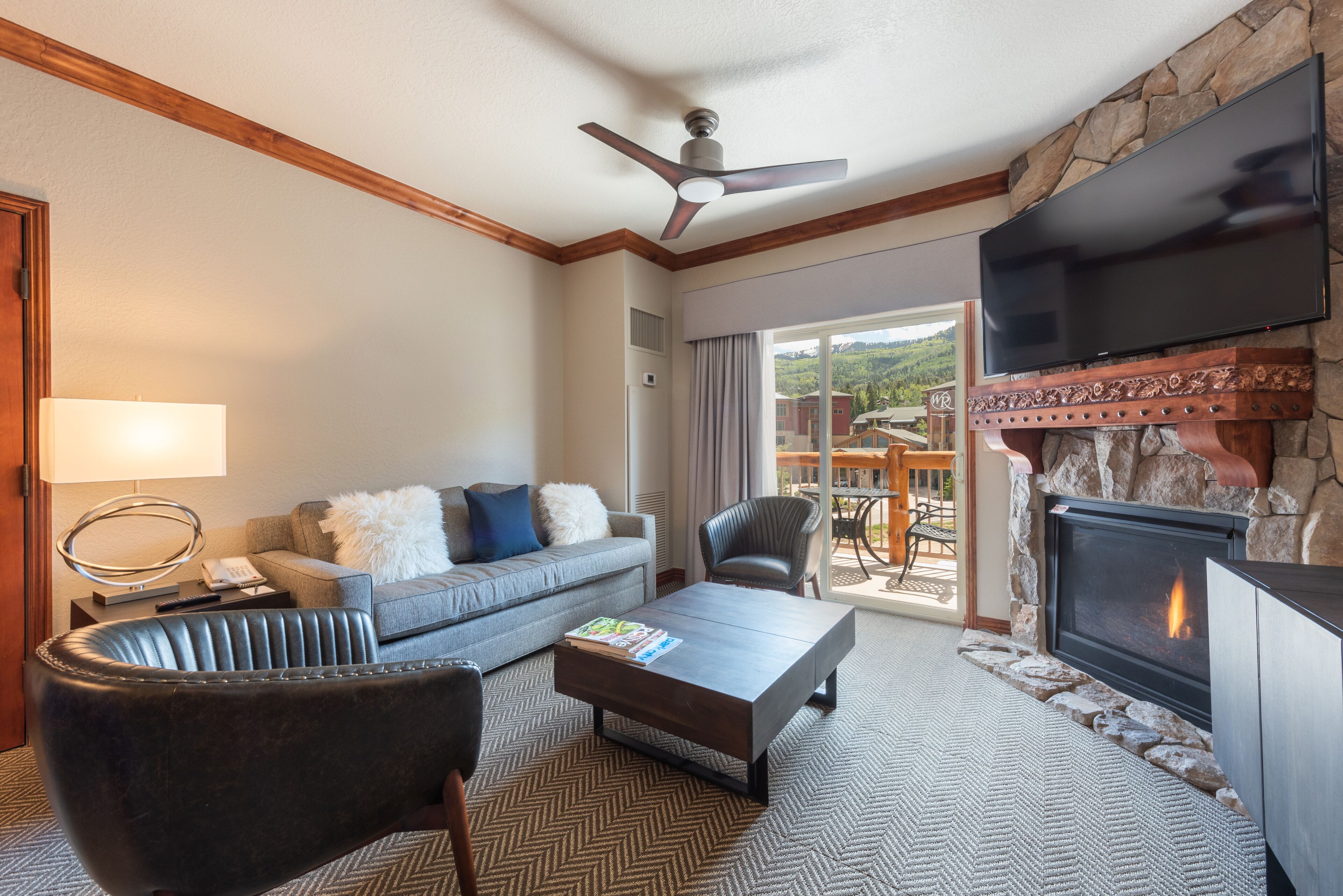 A living room with a fireplace, a sofa, a coffee table, and a television.