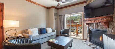 A living room with a fireplace, a sofa, a coffee table, and a television.