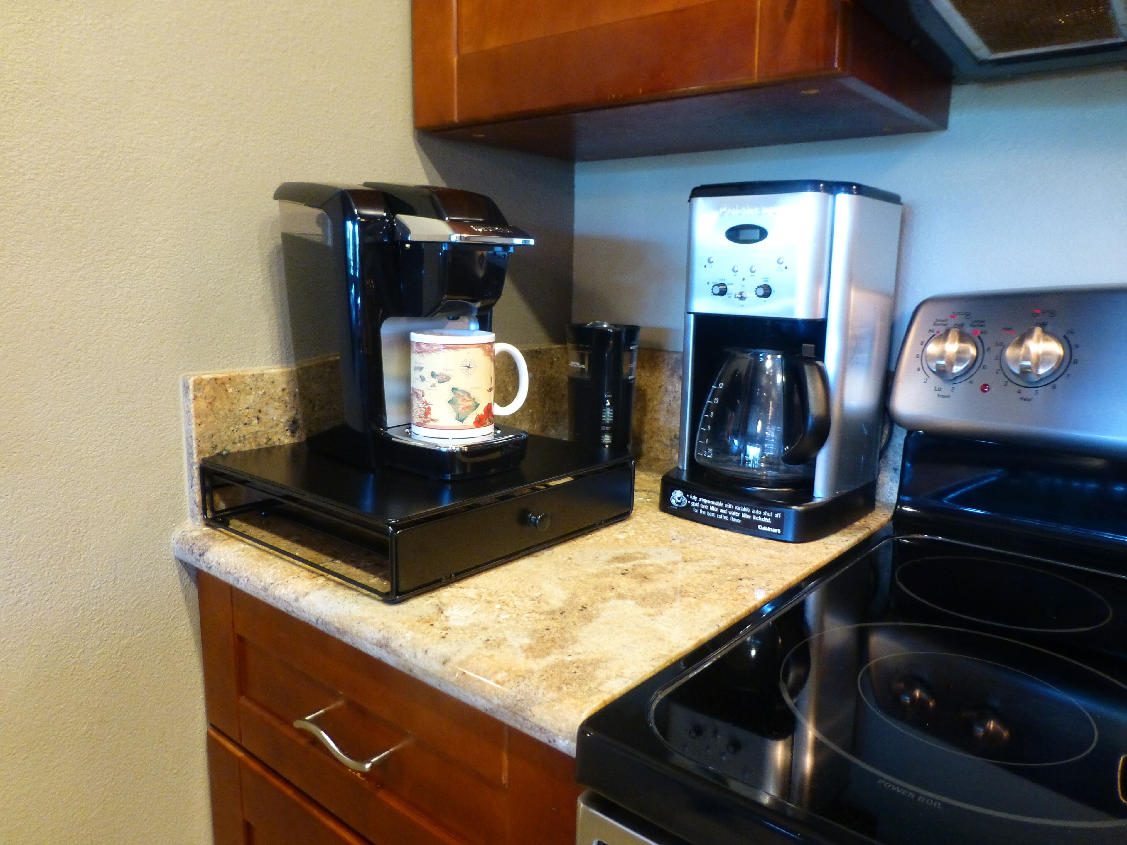 Una cocina equipada con cafetera, microondas y estufa.