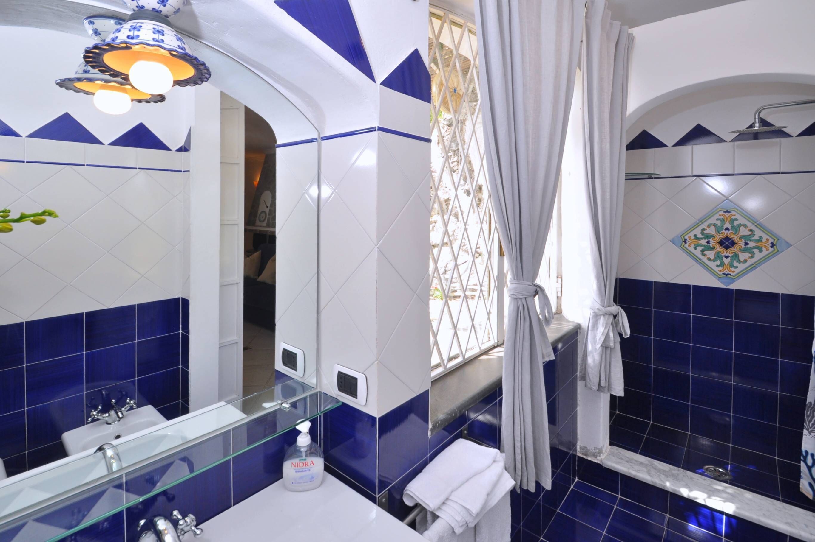 A bathroom with a glass sink, a white towel, and a shower curtain.