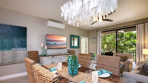 A dining area with wicker furniture, a table set for two, and a view of the outdoors. - Hula On In to Beach House Chic Style, Click the Video tour below! (Wailea)