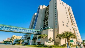 A high-rise hotel with a modern design, featuring a prominent glass entrance and a sign indicating it is a Wyndham hotel.