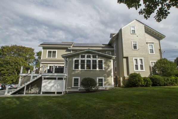 A two-story house with a front porch, a small front yard, and a staircase leading to the upper level.