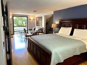 Une chambre dotée d’un grand lit, d’un coin repas et offrant une vue sur l’extérieur.