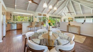 Une cuisine spacieuse avec un coin bar, une table à manger avec des chaises et un ventilateur de plafond.