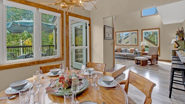 A dining area with a wooden table set for a meal, large windows, and a view of the outdoors. - Bright, spacious, & extra clean condo in heart of a perfect CO setting! (Keystone)