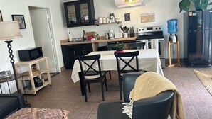 A modern kitchen with a dining area, featuring a microwave, stove, and dining table with chairs. - Red Rock Retreat: Hot tub, walk to creek for swimming,. (Sedona)