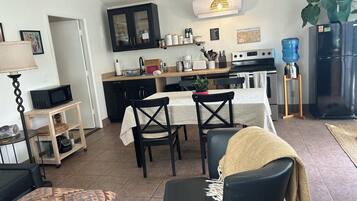 Una cocina moderna con comedor, que incluye microondas, estufa y mesa de comedor con sillas.