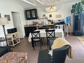 A modern kitchen with a dining area, featuring a microwave, stove, and dining table with chairs. - Red Rock Retreat: Hot tub, walk to creek for swimming,. (Sedona)