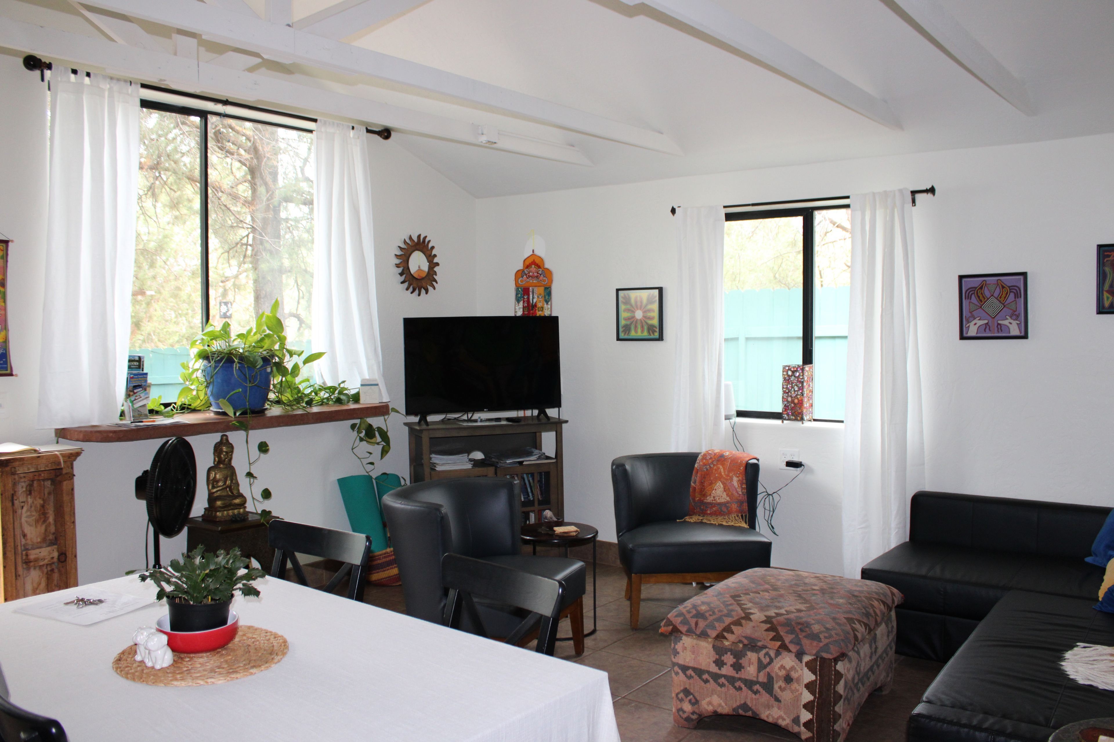 Una sala de estar con televisor, asientos y objetos decorativos.