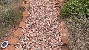 Un espace patio agrémenté d’un chemin en pierre, de sièges extérieurs et d’un jacuzzi couvert.