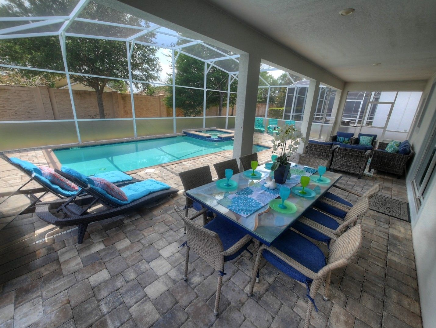 Une terrasse extérieure avec une piscine, des chaises longues et une table à manger pour six personnes.