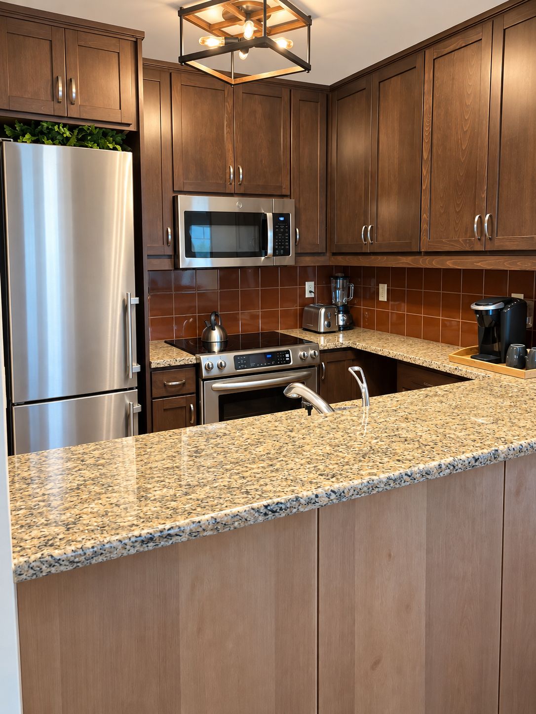 A kitchen with wooden cabinets, stainless steel appliances, a granite countertop, and a built-in oven.