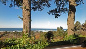A wooden deck overlooking a coastal landscape with trees and a view of the ocean. - Gorgeous Ocean View! Private. Cozy Comfort. (Neskowin)