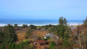 A coastal property with a wooden house, a deck, and a view of the ocean. - Gorgeous Ocean View! Private. Cozy Comfort. (Neskowin)