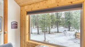L'intérieur d'une cabine doté d'une grande fenêtre, d'un plafond en bois et de deux canapés gris.
