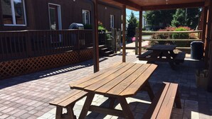 A wooden deck with picnic tables and a covered seating area.