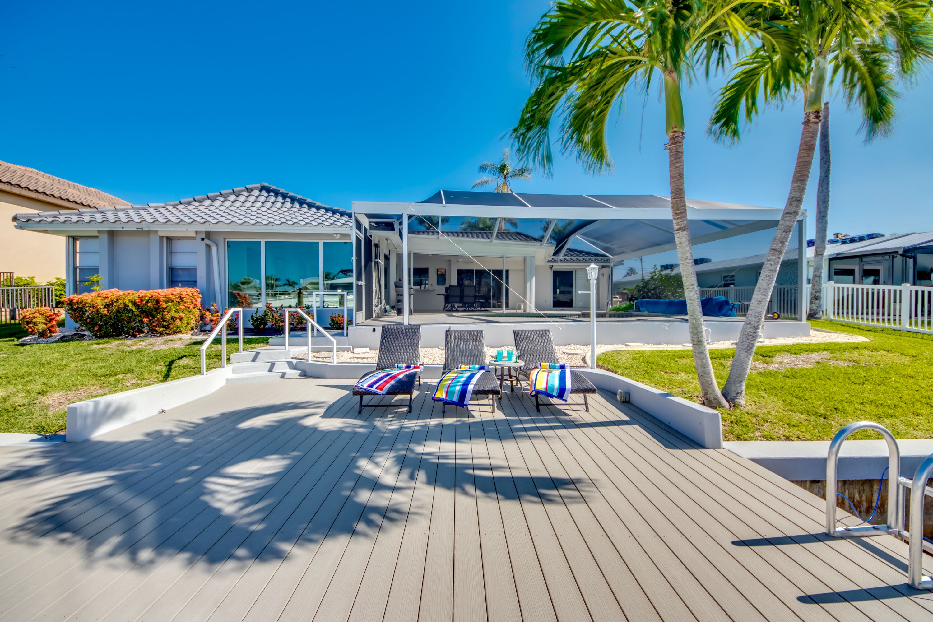 A modern outdoor deck with lounge chairs and a pool area.