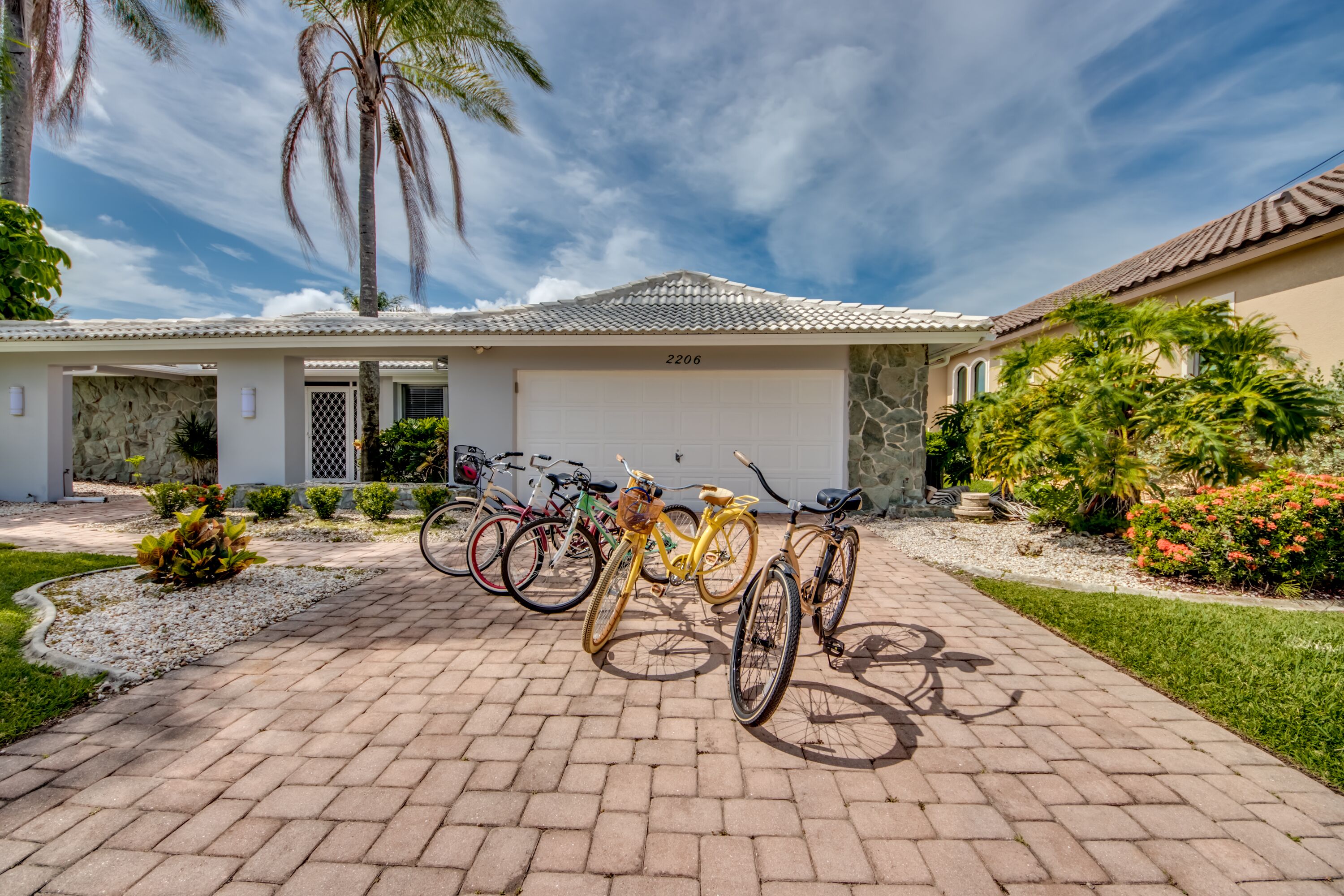 Una propiedad residencial con garaje, bicicletas y un jardín bien cuidado.