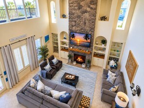 Un salón amplio con chimenea de piedra, asientos cómodos y televisor.