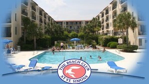 A pool area with lounge chairs and a building with balconies. - Cozy beach unit setup for vacations with kids or Couples!  (St Simons Island)