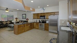 A modern kitchen with wooden cabinets, stainless steel appliances, and a central island. - Vacation Townhome - Hot Tub, Red Rock Views, Walk to Dining/Trails (Sedona)